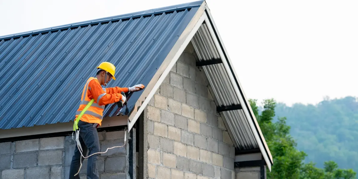 Professional roofer inspecting asphalt shingles before applying a protective roof coating to improve weather resistance and help prevent leaks