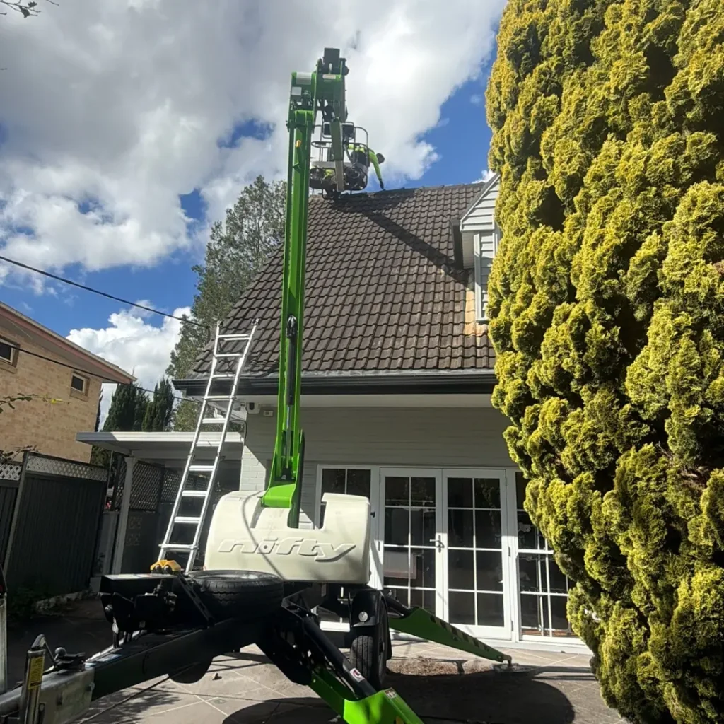 Roof maintenance contractor accessing a residential tiled roof using an elevated work platform
